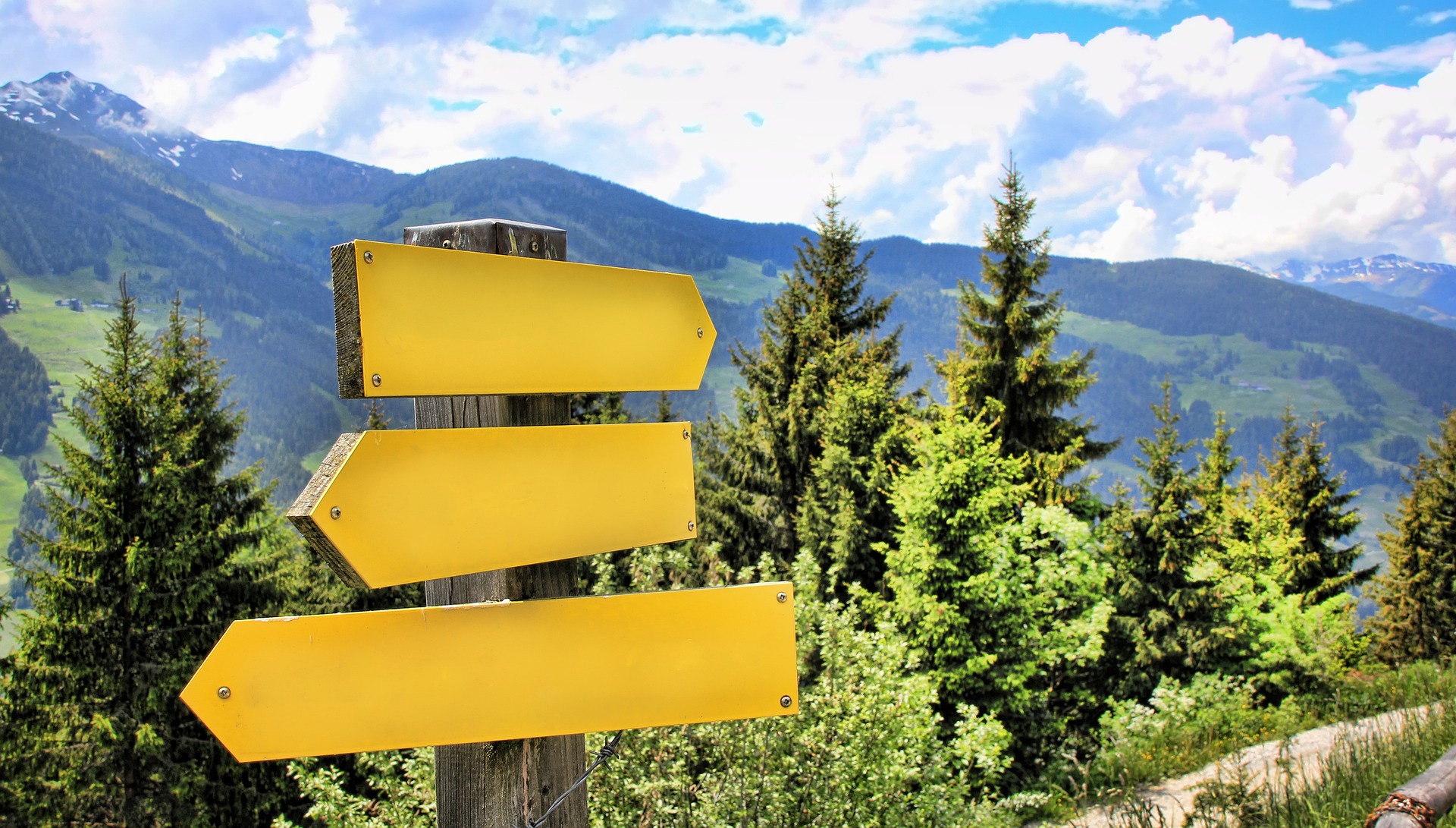 Directional signs in front of a mountain vista