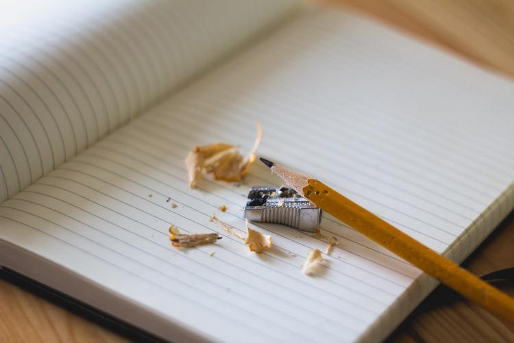pencil with sharpening shavings and notebook