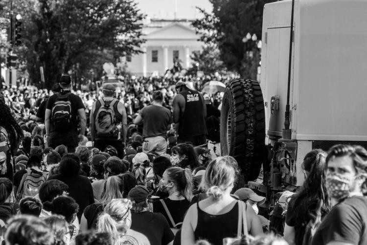 Peaceful protestors on 16th St. facing the White House, by a military truck